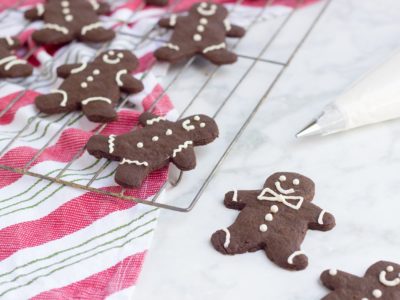 gingerbread cookies with red and green striped towel on white backdrop